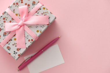 Çiçek desenli hediye kutusu pembe bir arka plan üzerinde