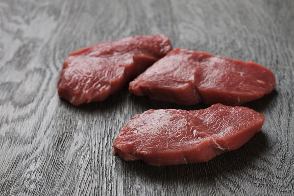 A sötét fa deszkán nyers marha steak — Stock Fotó