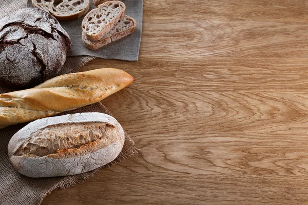 Assortimento di pane al forno su fondo di legno — Foto Stock