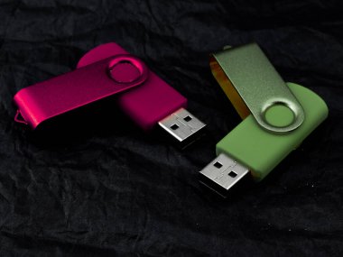 couple of coloured pen drive on dark background clipart
