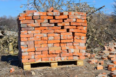 Bir paletin üzerinde bir yığın eski tuğla. İnşaat malzemeleri satışı.