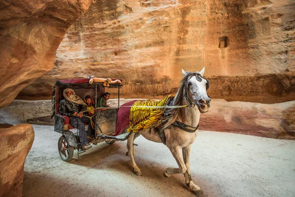 PETRA, JORDANIA - 17 DE MARZO DE 2016: Tres beduinos montando un caballo ca — Foto de Stock