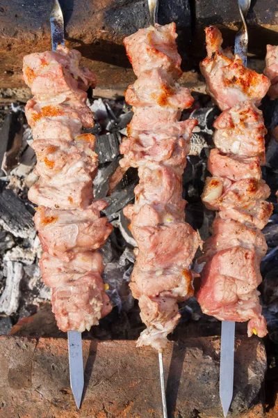 Cuisson de viande de porc tranchée sur des brochettes — Photo