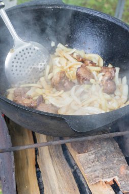 Yazın dışarıdaki ızgarada kazanda pilav pişirmek.