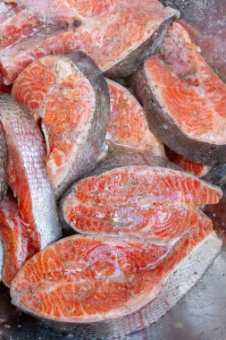 Taze alabalık biftekleri pişirmeden önce metal bir kasede marine edilir.