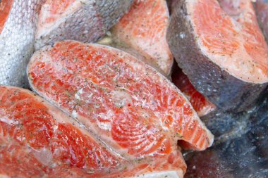 Taze alabalık biftekleri pişirmeden önce metal bir kasede marine edilir.