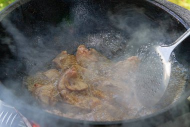 Yazın dışarıdaki ızgarada kazanda pilav pişirmek.