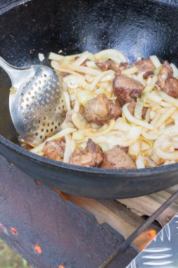 Yazın dışarıdaki ızgarada kazanda pilav pişirmek.