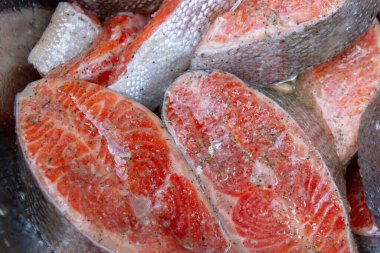 Taze alabalık biftekleri pişirmeden önce metal bir kasede marine edilir.