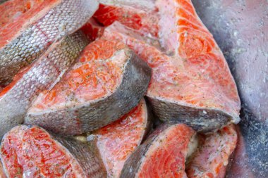 Taze alabalık biftekleri pişirmeden önce metal bir kasede marine edilir.