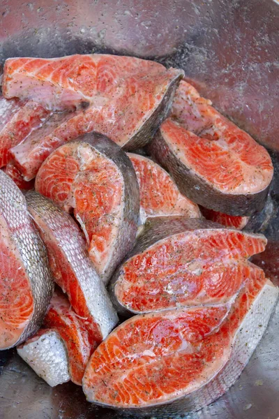 Taze alabalık biftekleri pişirmeden önce metal bir kasede marine edilir.