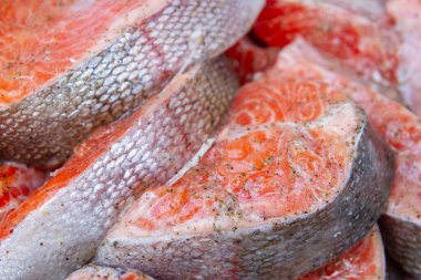 Taze alabalık biftekleri pişirmeden önce metal bir kasede marine edilir.