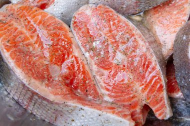 Taze alabalık biftekleri pişirmeden önce metal bir kasede marine edilir.