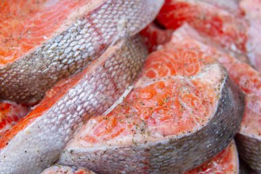 Taze alabalık biftekleri pişirmeden önce metal bir kasede marine edilir.