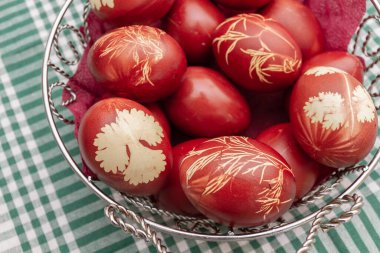 Soyut çizimlerle birlikte soğan kabuklarında boyanmış Paskalya yumurtaları sepette.