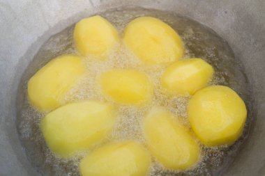 Altın patatesler kazanda kaynar yağda kızartılır.