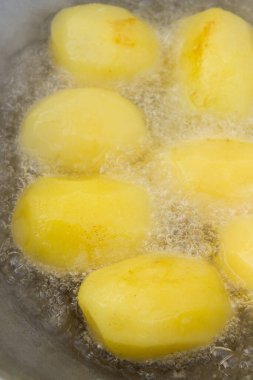 Altın patatesler kazanda kaynar yağda kızartılır.