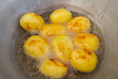 Altın patatesler kazanda kaynar yağda kızartılır.