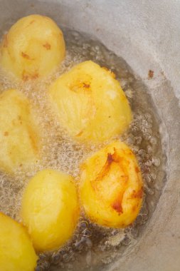 Altın patatesler kazanda kaynar yağda kızartılır.