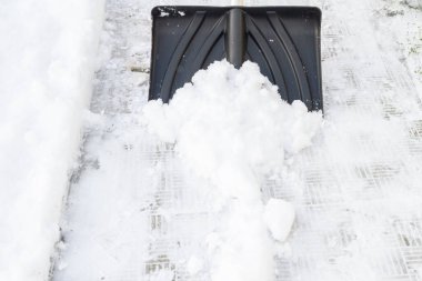 Kışın büyük bir kürekle kar temizleme