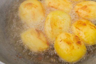 Altın patatesler kazanda kaynar yağda kızartılır.