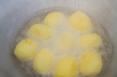 Altın patatesler kazanda kaynar yağda kızartılır.