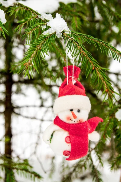 Spielzeug-Schneemann hängt an einem schneebedeckten Baum — Stockfoto