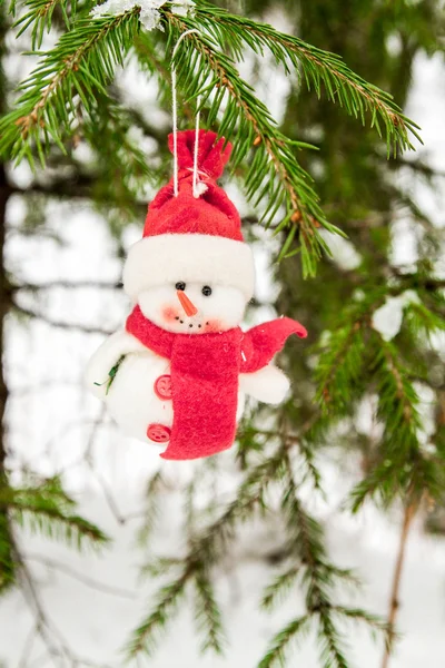 Spielzeug-Schneemann hängt an einem schneebedeckten Baum — Stockfoto
