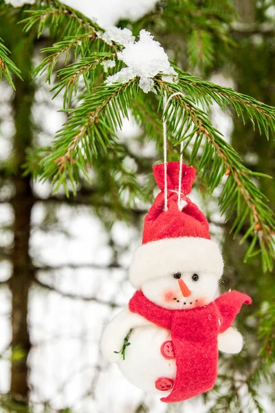 Spielzeug-Schneemann hängt an einem schneebedeckten Baum — Stockfoto