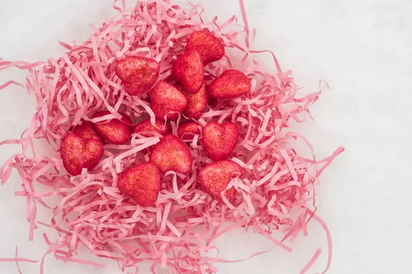 Corazones rosados en un nido de papel en la nieve — Foto de Stock