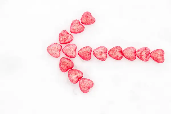 Arrow of pink hearts in the snow — Stock Photo, Image
