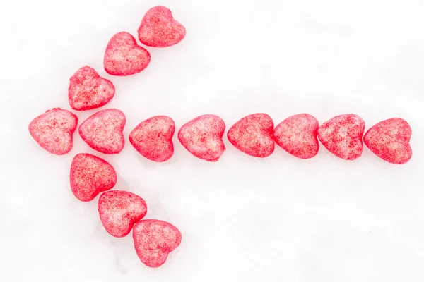 Arrow of pink hearts in the snow — Stock Photo, Image