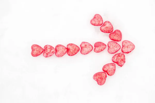 Arrow of pink hearts in the snow — Stock Photo, Image