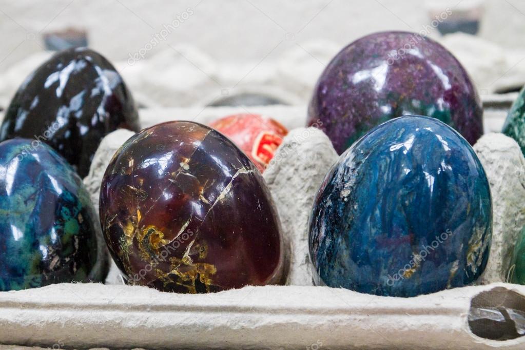 Multicolored marble eggs of stone in cells — Stock Photo
