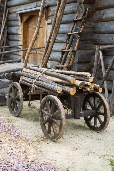 Vieux chariot en bois avec bûches attachées dessus — Photo