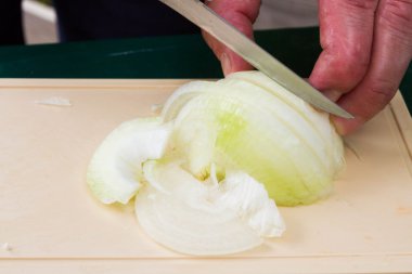 Kesme tahtası üzerinde dilimlenmiş soğan ve mutfak bıçağı