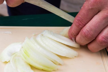 Kesme tahtası üzerinde dilimlenmiş soğan ve mutfak bıçağı