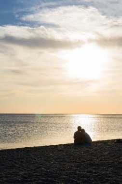 Sahilde gün batımında severler