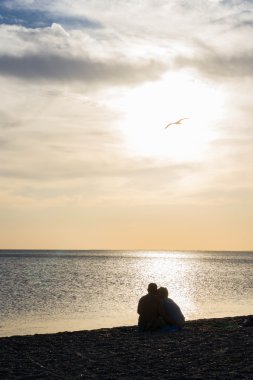 Sahilde gün batımında severler