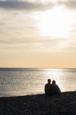 Sahilde gün batımında severler