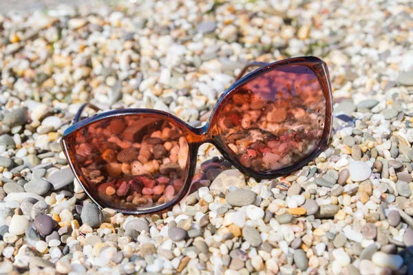 Sluneční brýle na pláži malé oblázky — Stock fotografie