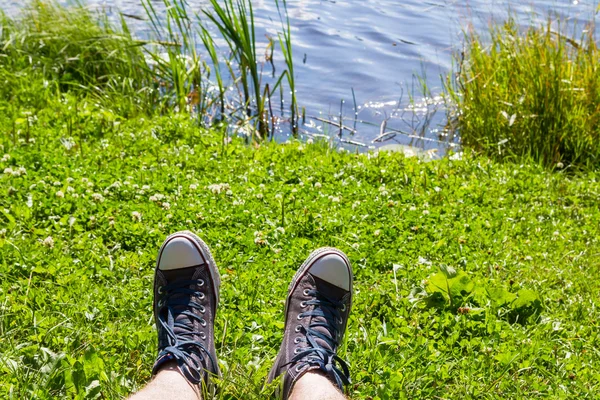 Sportskor på fötterna i sommar på gräset — Stockfoto