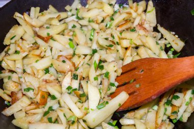 Kızarmış patates yeşil soğan ile bir tavada pişmiş