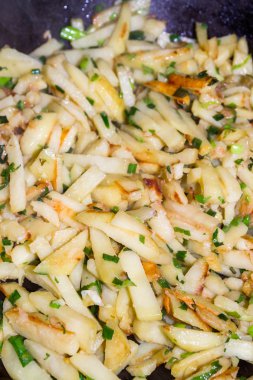 Kızarmış patates yeşil soğan ile bir tavada pişmiş