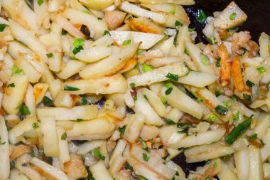 Kızarmış patates yeşil soğan ile bir tavada pişmiş