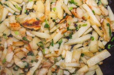 Kızarmış patates yeşil soğan ile bir tavada pişmiş