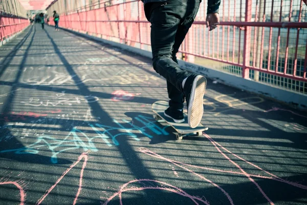 Skateboarder cruise op brug — Stockfoto