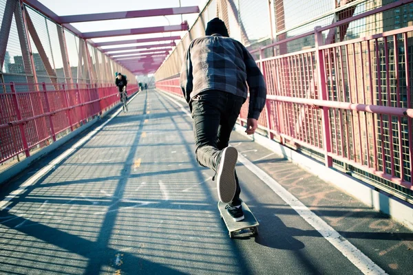 Skateboarder cruise on bridge Stock Image