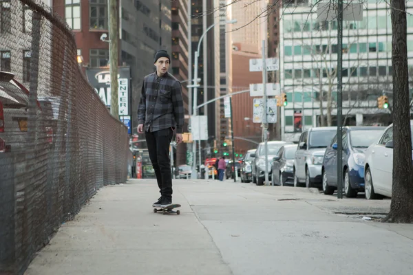 Full front figure of a skateboarder cruising down city street be — Stock Photo, Image