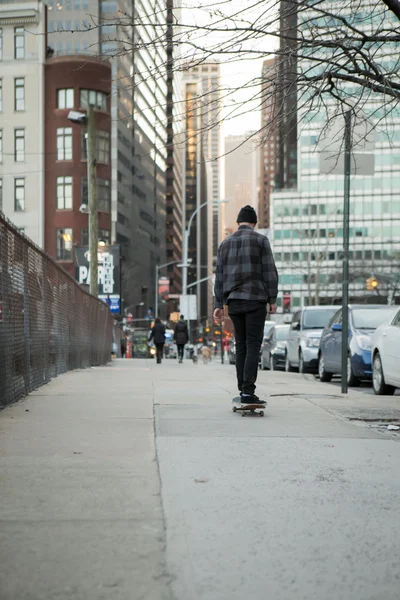 Volledige terug figuur van een skateboarder cruisen naar beneden stad straat — Stockfoto
